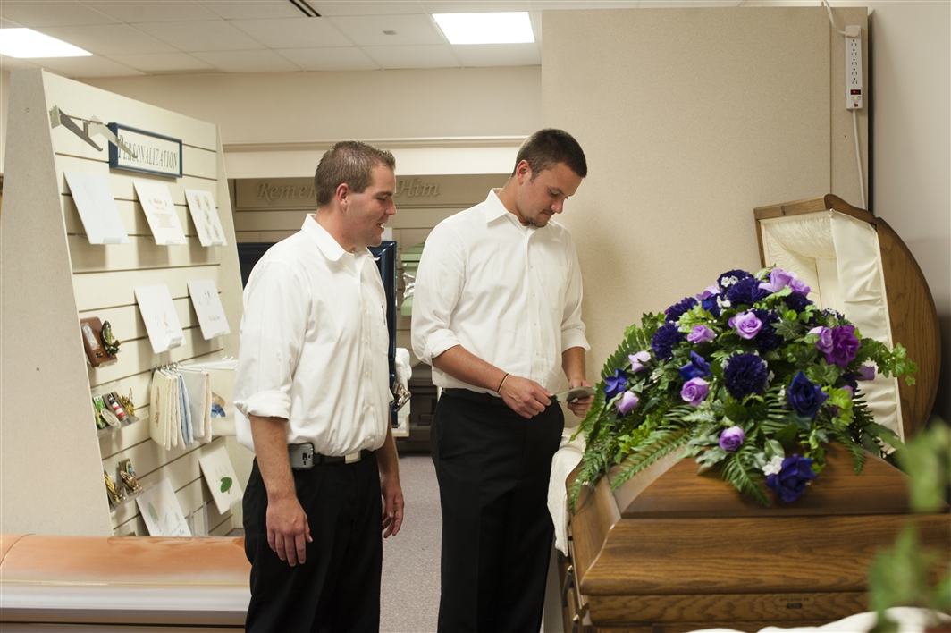 two students by casket in merchandise room